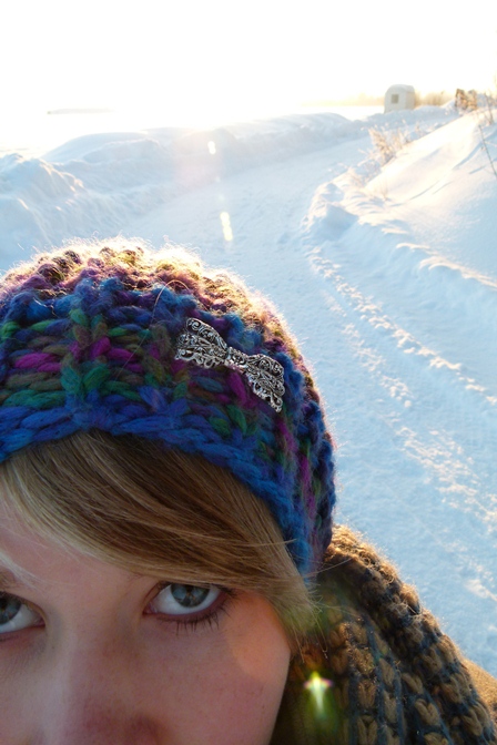 © Sara Schnur Frau mit blauem Stirnband auf tiefverschneitem Weg.